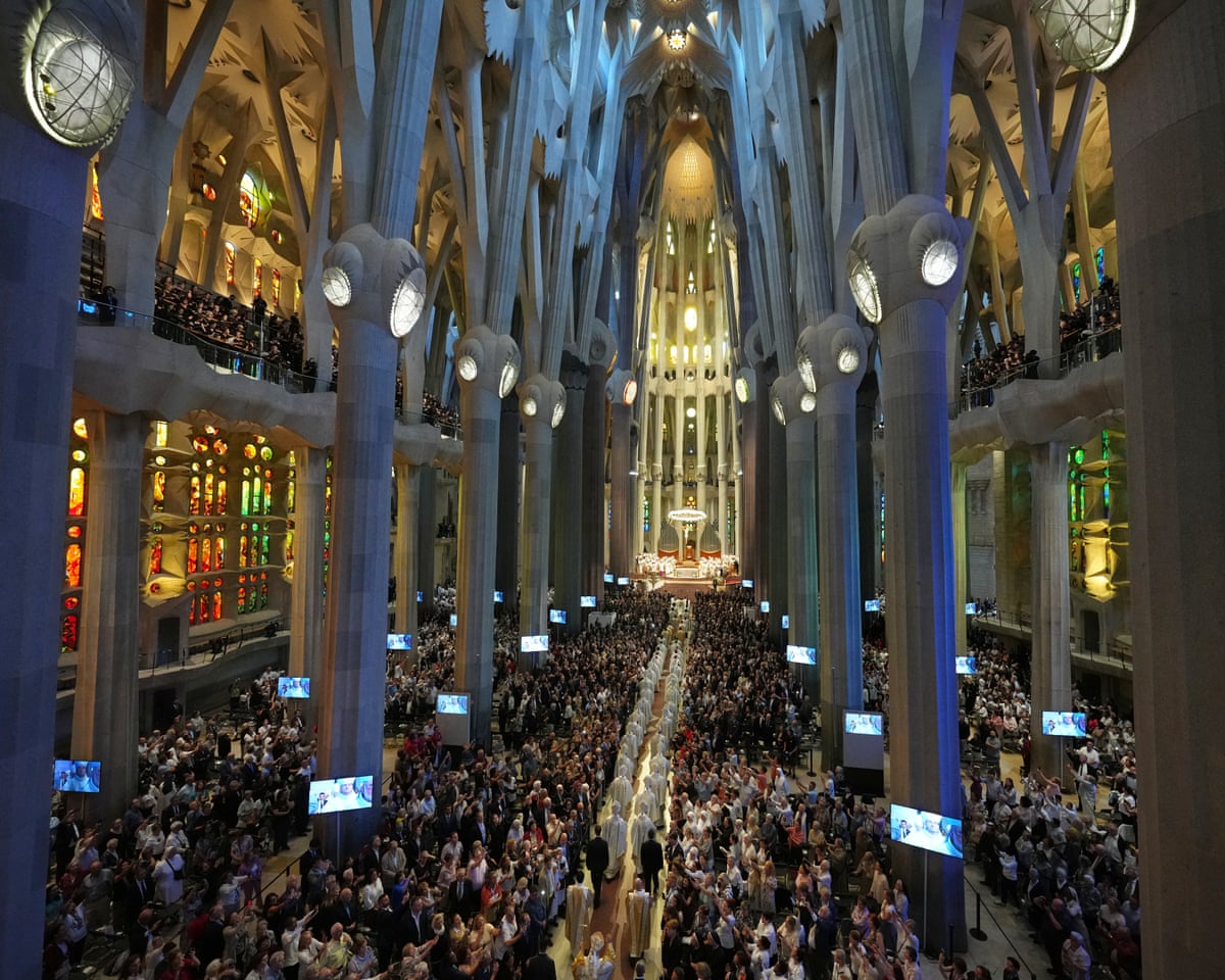 Wide view of the basilica filled with people and a procession of clergy down the centre