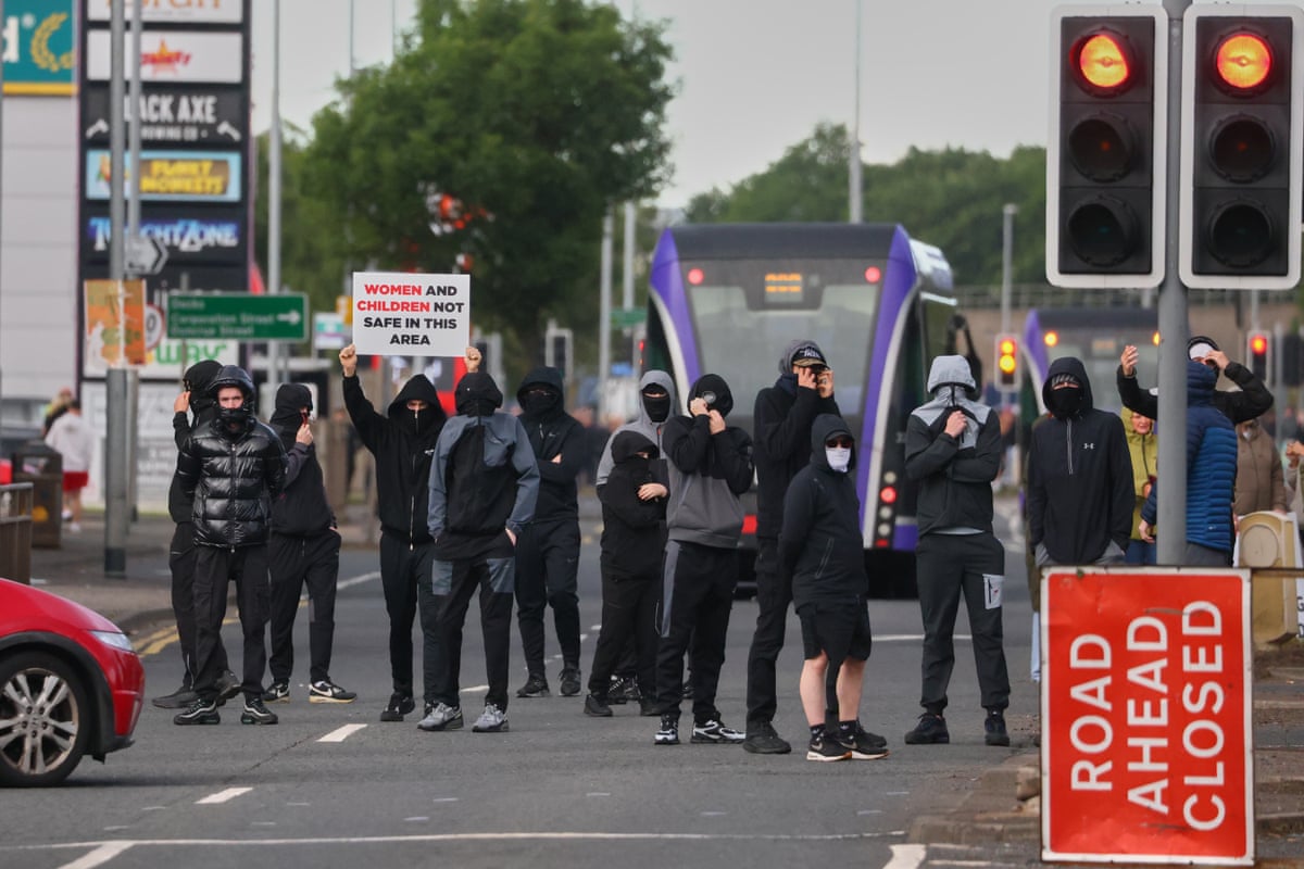 A crowd of protesters gathering in a road in Belfast the day after the stabbing.