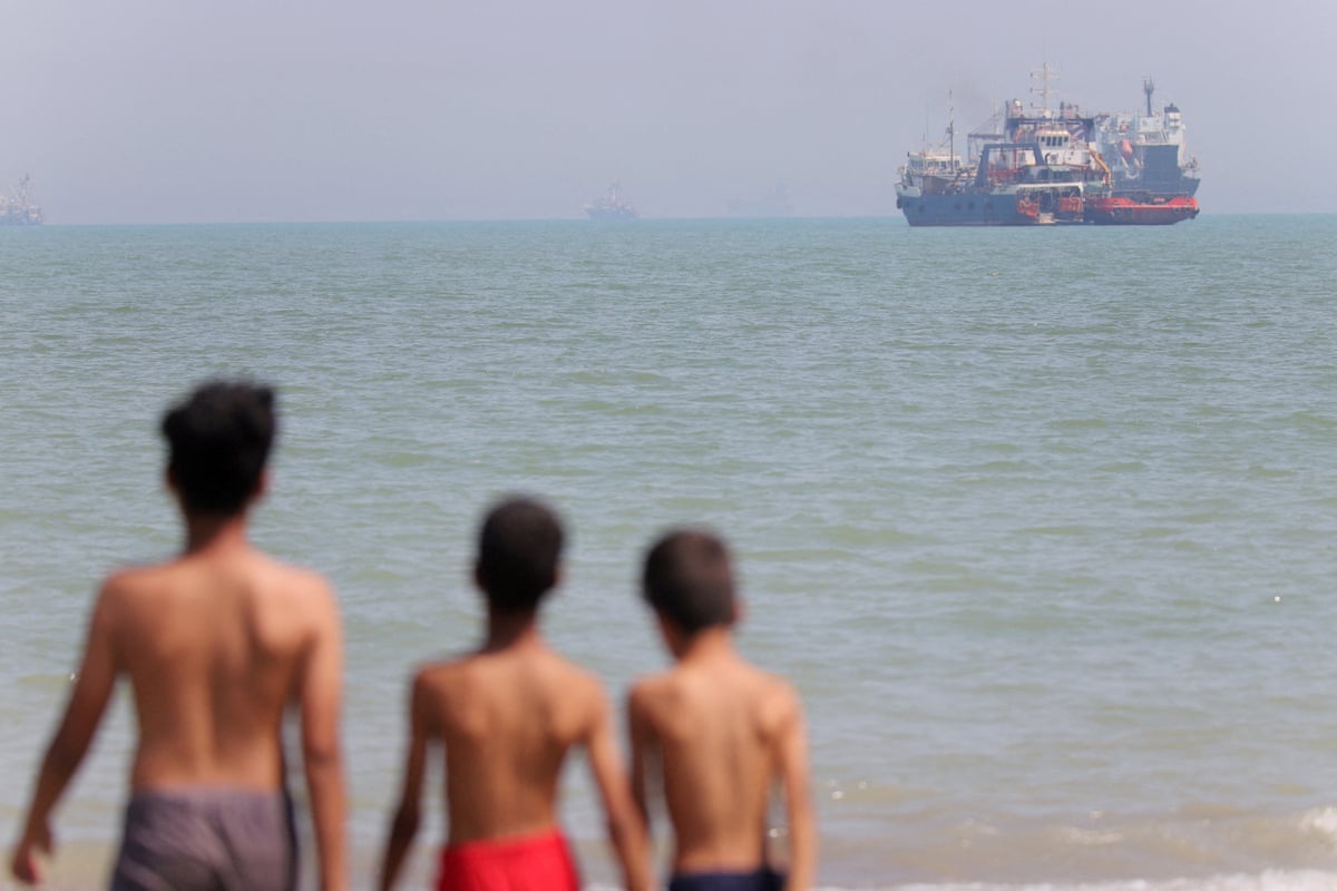 Boys look at a ship in the distance