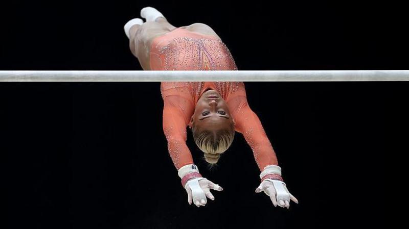 Ruby Evans upside down in the air as she competes on the uneven bars