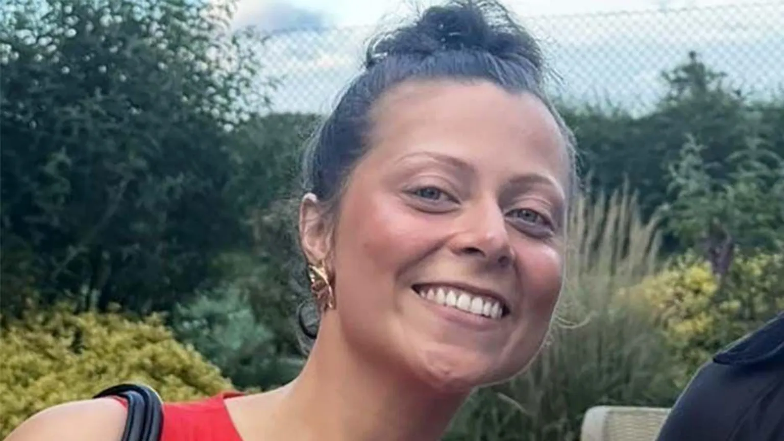 Ella Woman with brown hair in a bun smiling at camera 