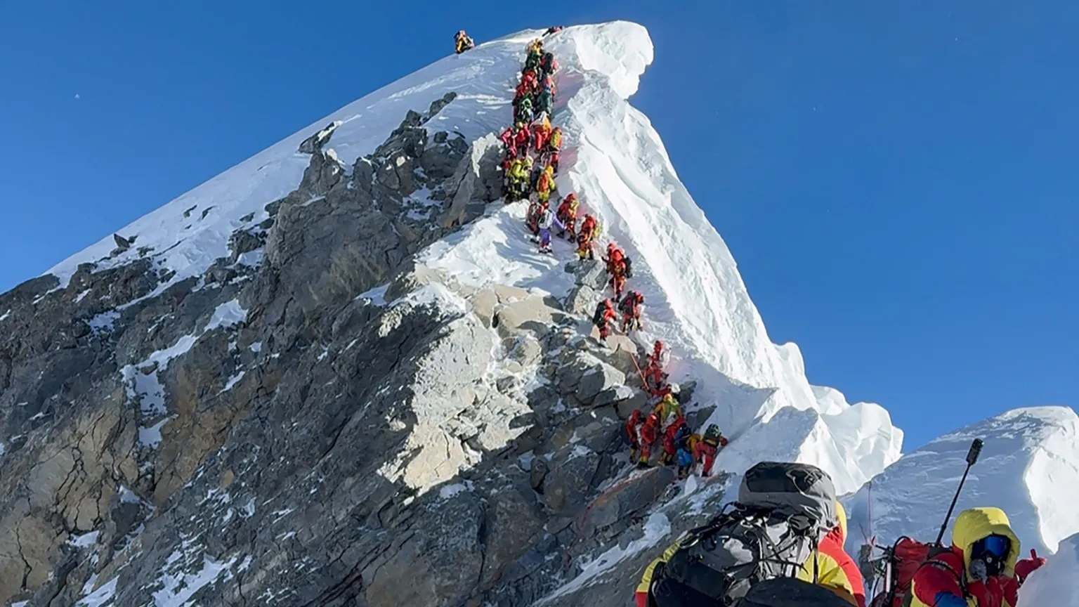 A line of climbers walking up to the summit of Mount Everest.