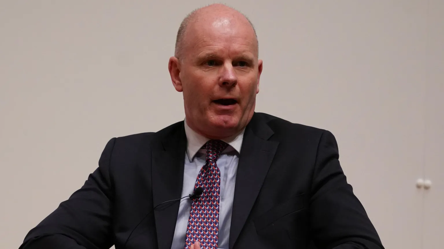 Brian Lawless/PA Wire A man in a black suit with a blue shirt and red patterned tie. He is bald.