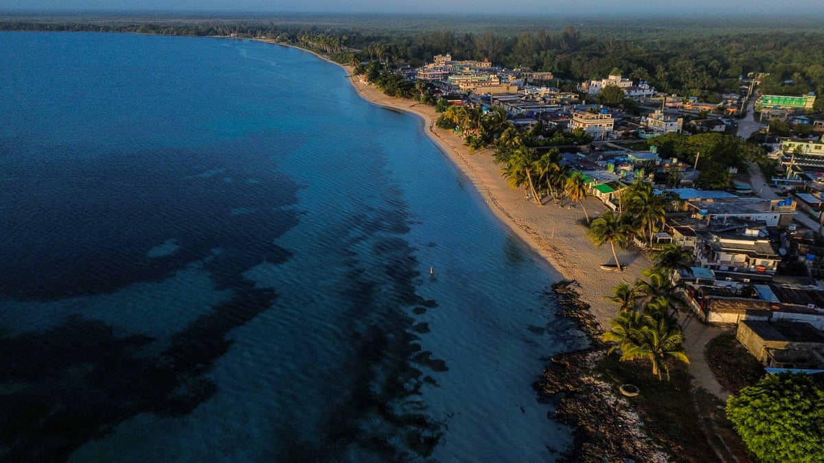 Aerial view of the town of Playa Larga, Cuba, with palm trees, beach and blue seas.