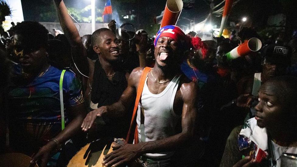 Fans in Port-au-Prince celebrate Haiti's World Cup qualification, one is beating a drum