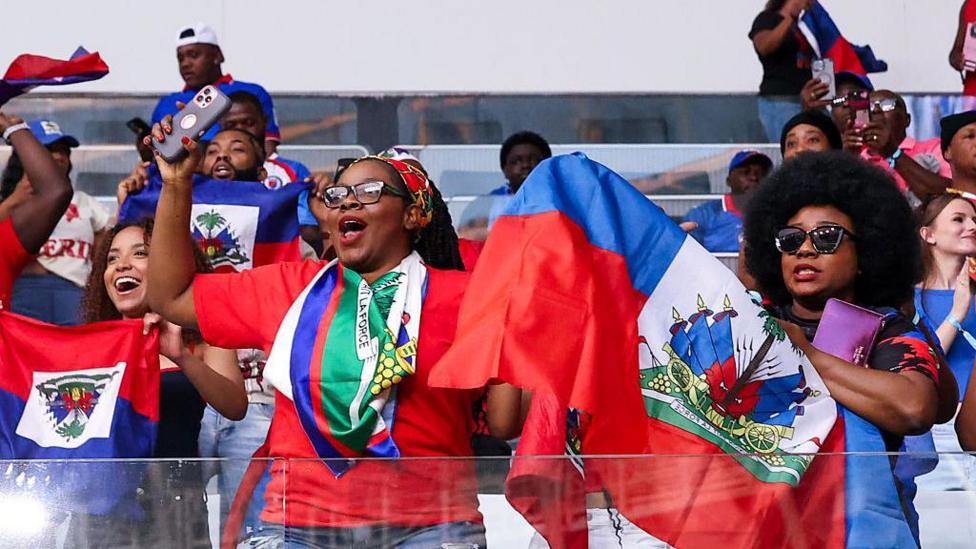 Haiti fans wave flags at the World Cup warm-up match against Peru