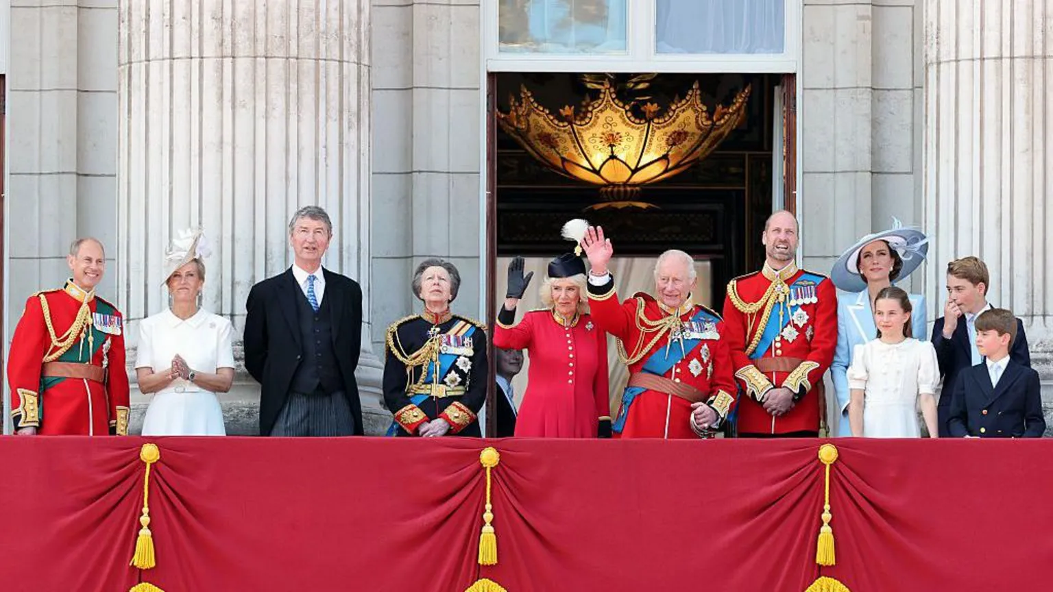 Members of the Royal Family stand on the Buckingham Palace balcony. From left to right: The Duke and Duchess of Edinburgh, Vice Admiral Sir Timothy Laurence and the Princess Royal, Queen Camilla and the King, the Prince and Princess of Wales, and Princess Charlotte, Prince George and Prince Louis