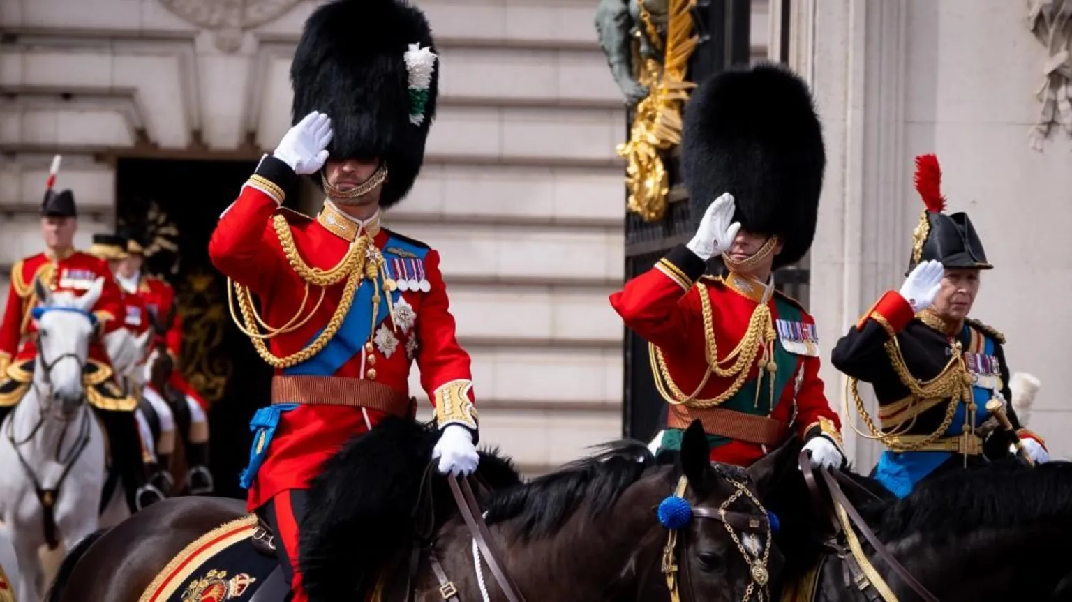Prince William, Prince Edward and Princess Anne in full military regailia, riding on horseback