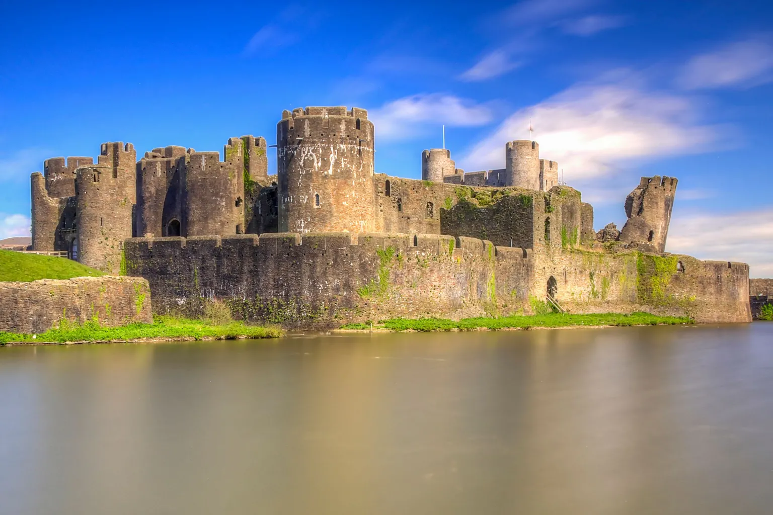 Caerphilly Castle, its moat under blue sky