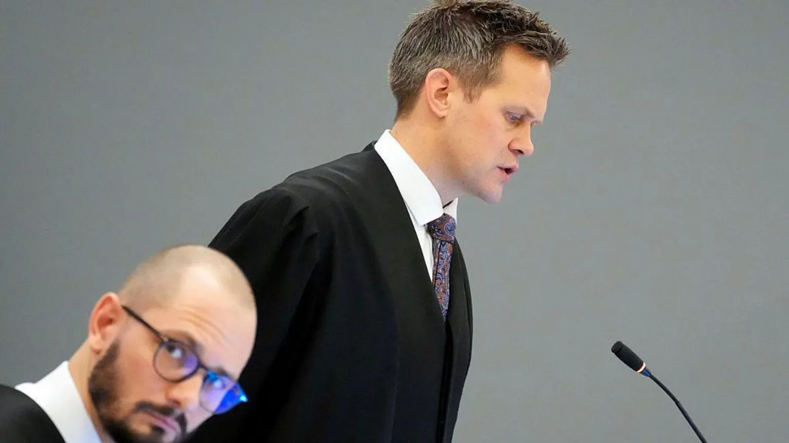 AFP via A man in a gown and tie speaks in front of a microphone