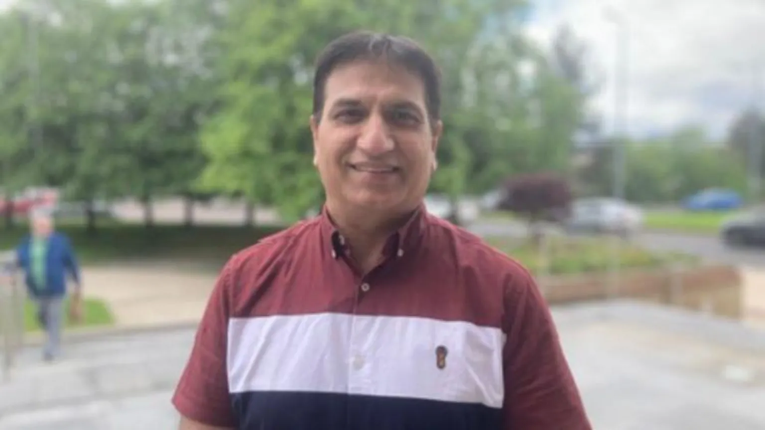 Dr Mukesh Chugh. He has dark hair, wearing a red, white and navy shirt.