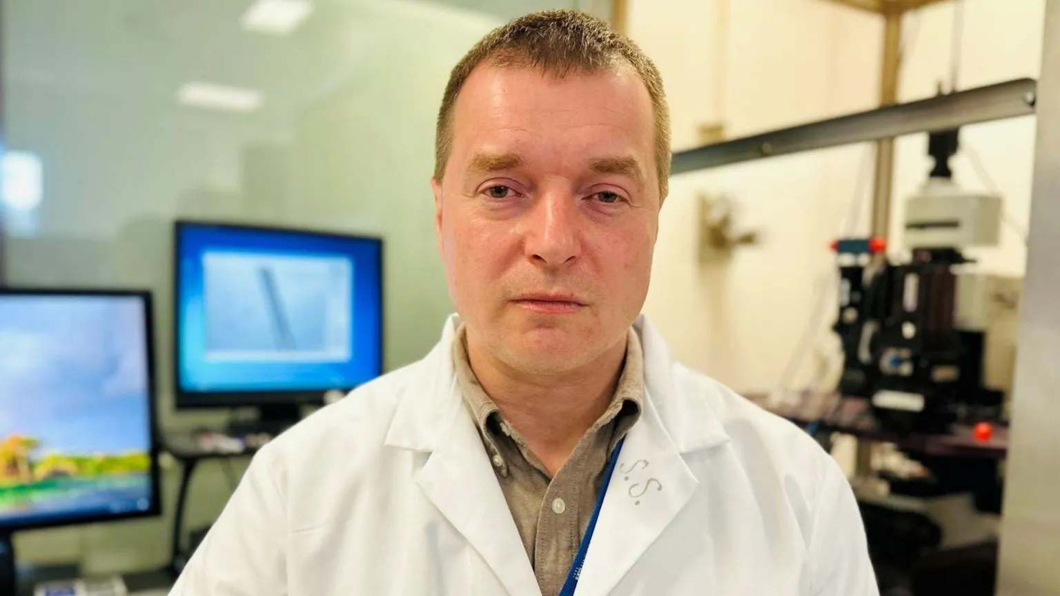 Sergiy Sylantyev, a man in a white lab coat in a lab setting, looking at the camera.