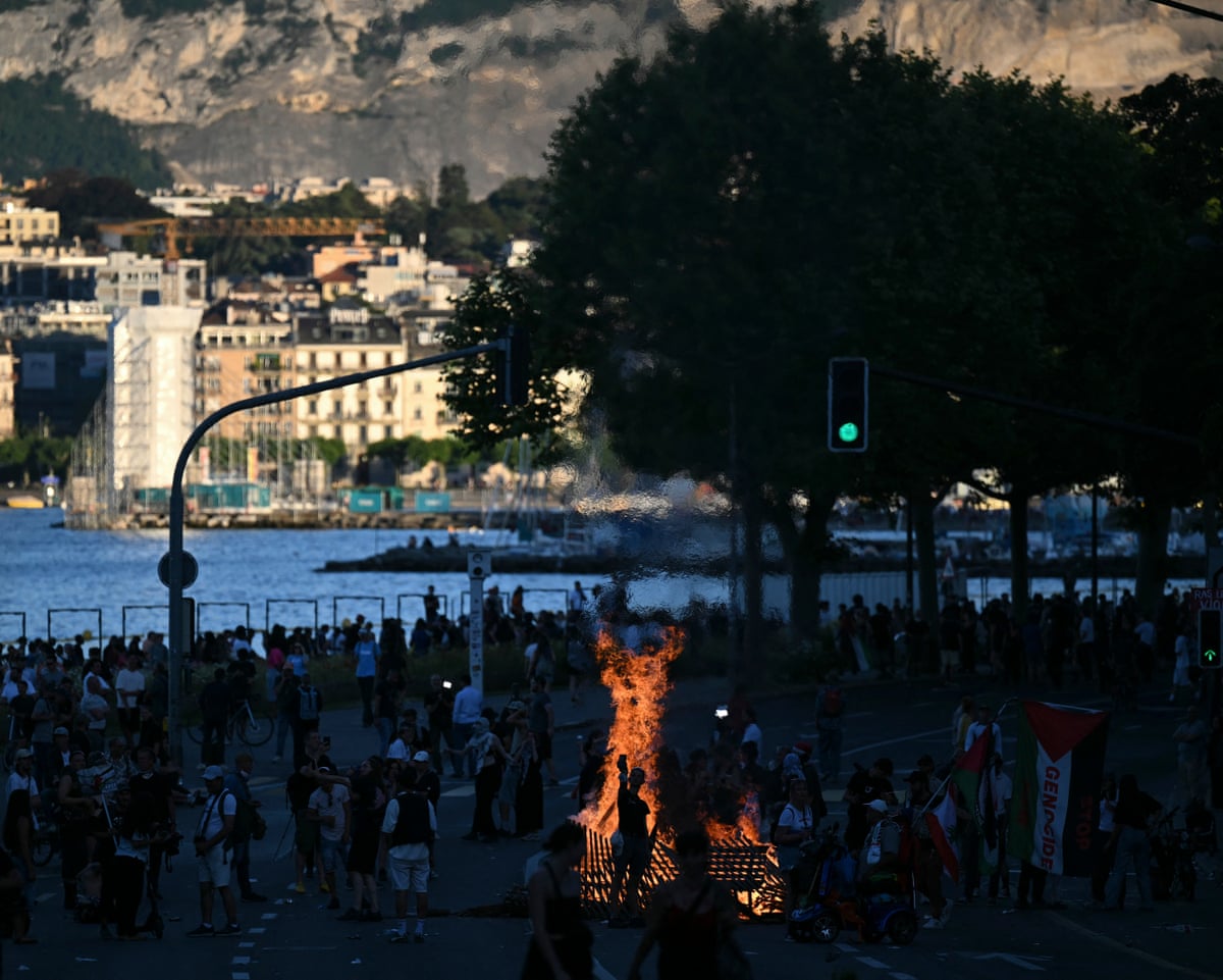 A fire burning in a street with the Lake Geneva in the background during a rally of a “No-G7” coalition of over 60 associations, unions and left-wing groups.