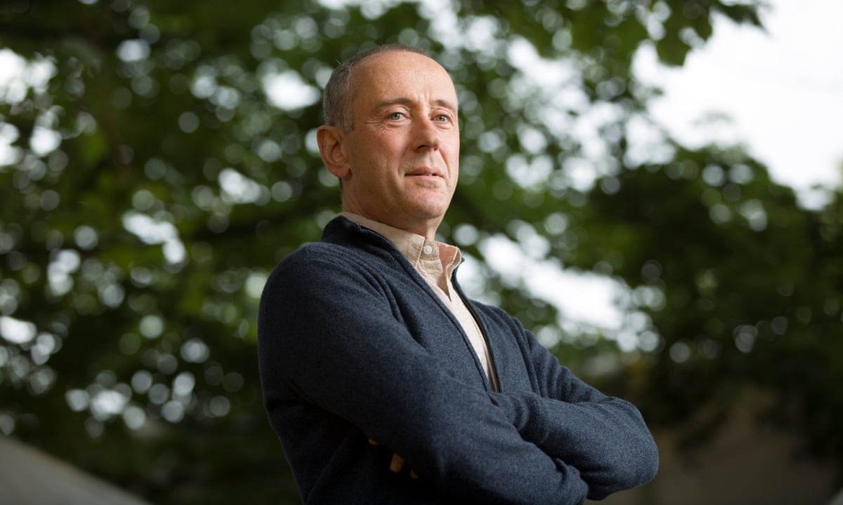 Nicholas Hytner stands beside a tree