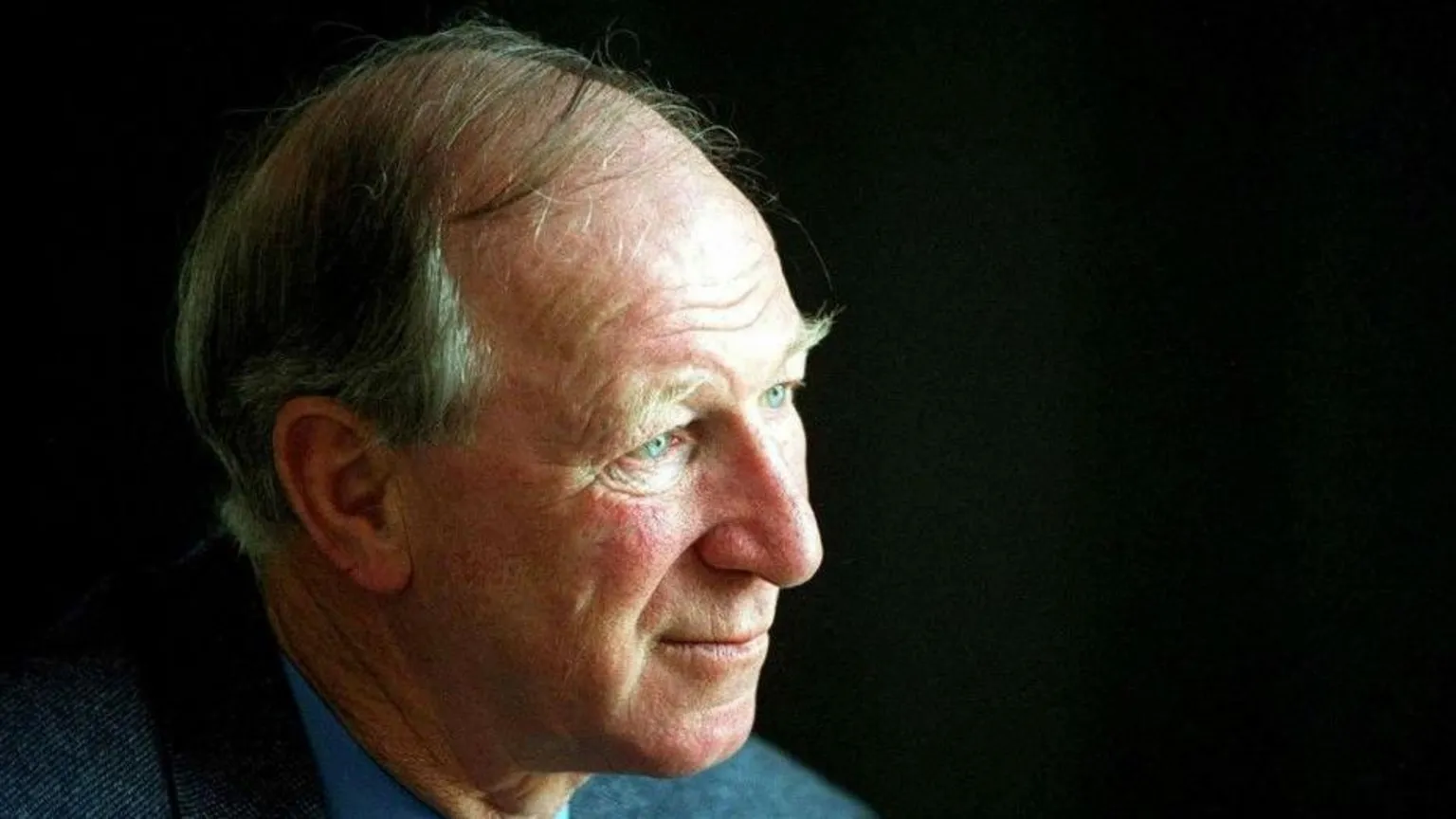 Jack Charlton, a man with grey hair, wearing a grey jacket and blue shirt.