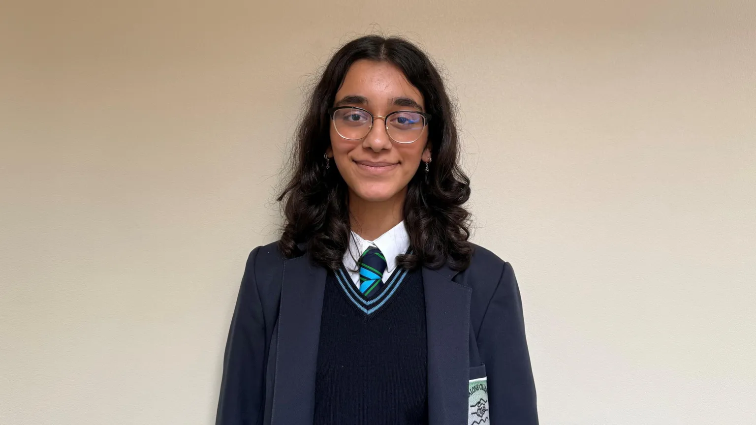 Siya. She has shoulder-length dark hair, wearing glasses and a navy school uniform.