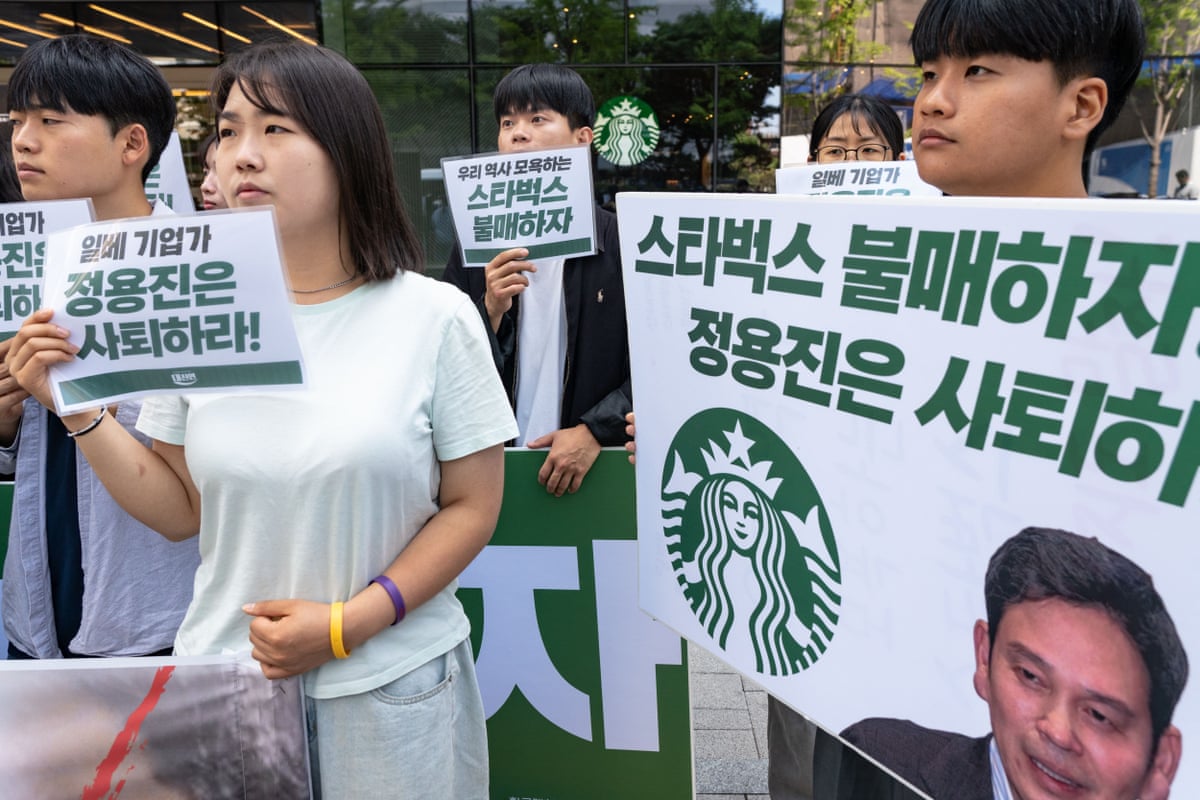 People hold placards protesting against the Starbucks promotion