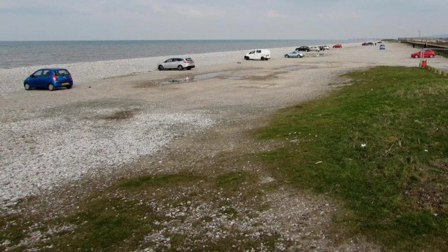 Geograph/Jaggery Wide shingle beach with cars parked facing the sea