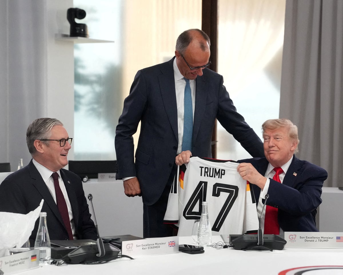 US president Donald Trump holds up a German national team football shirt with the number 47.