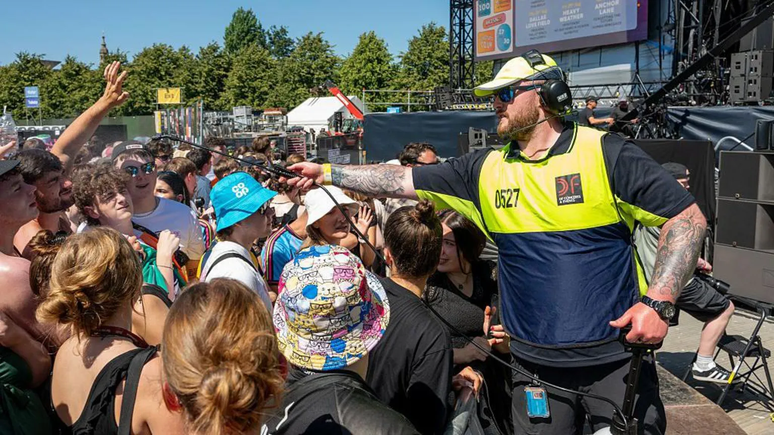  A steward sprays music fans with water during a music festival