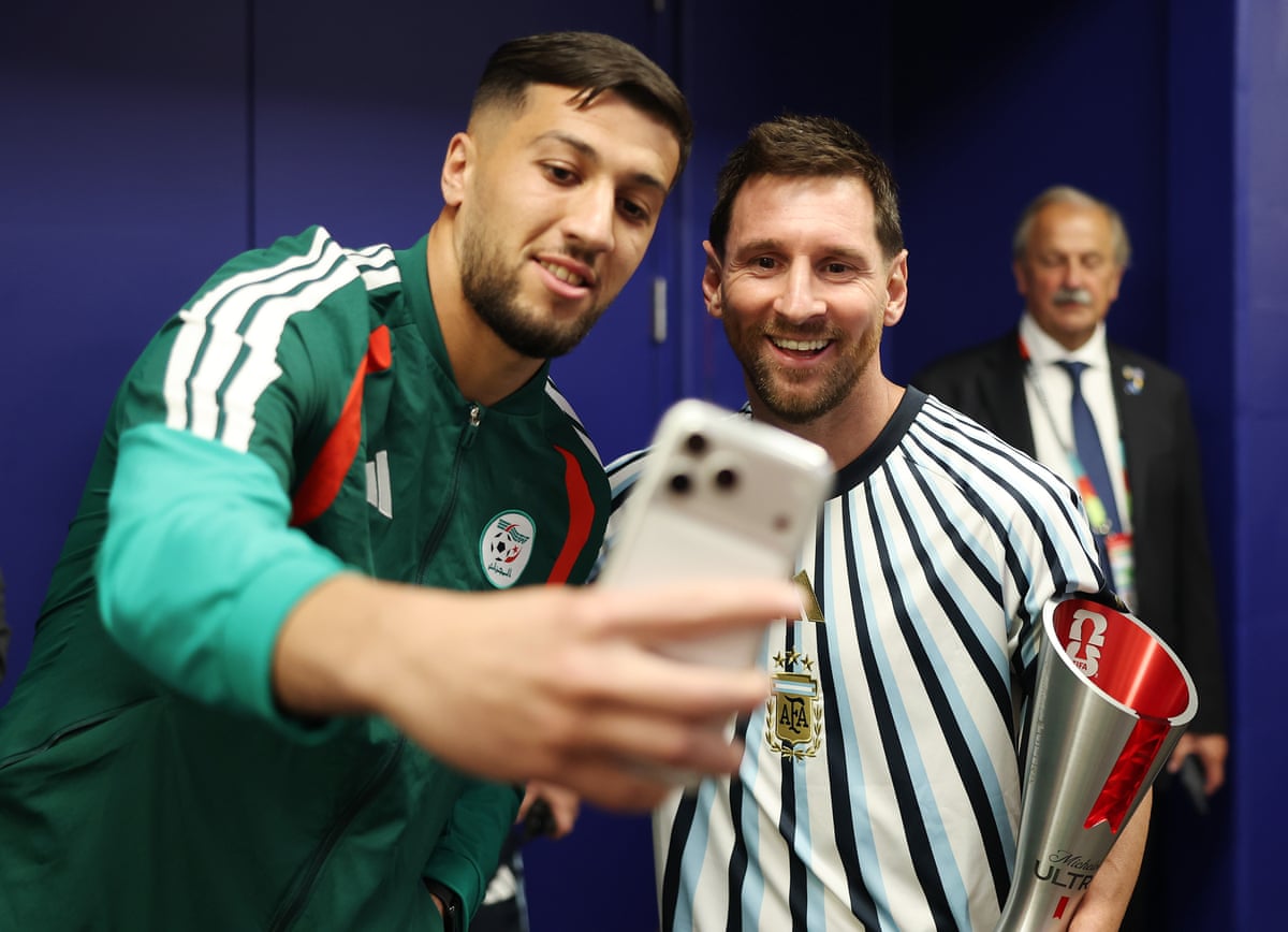 Lionel Messi of Argentina poses for selfie with an official of Algeria