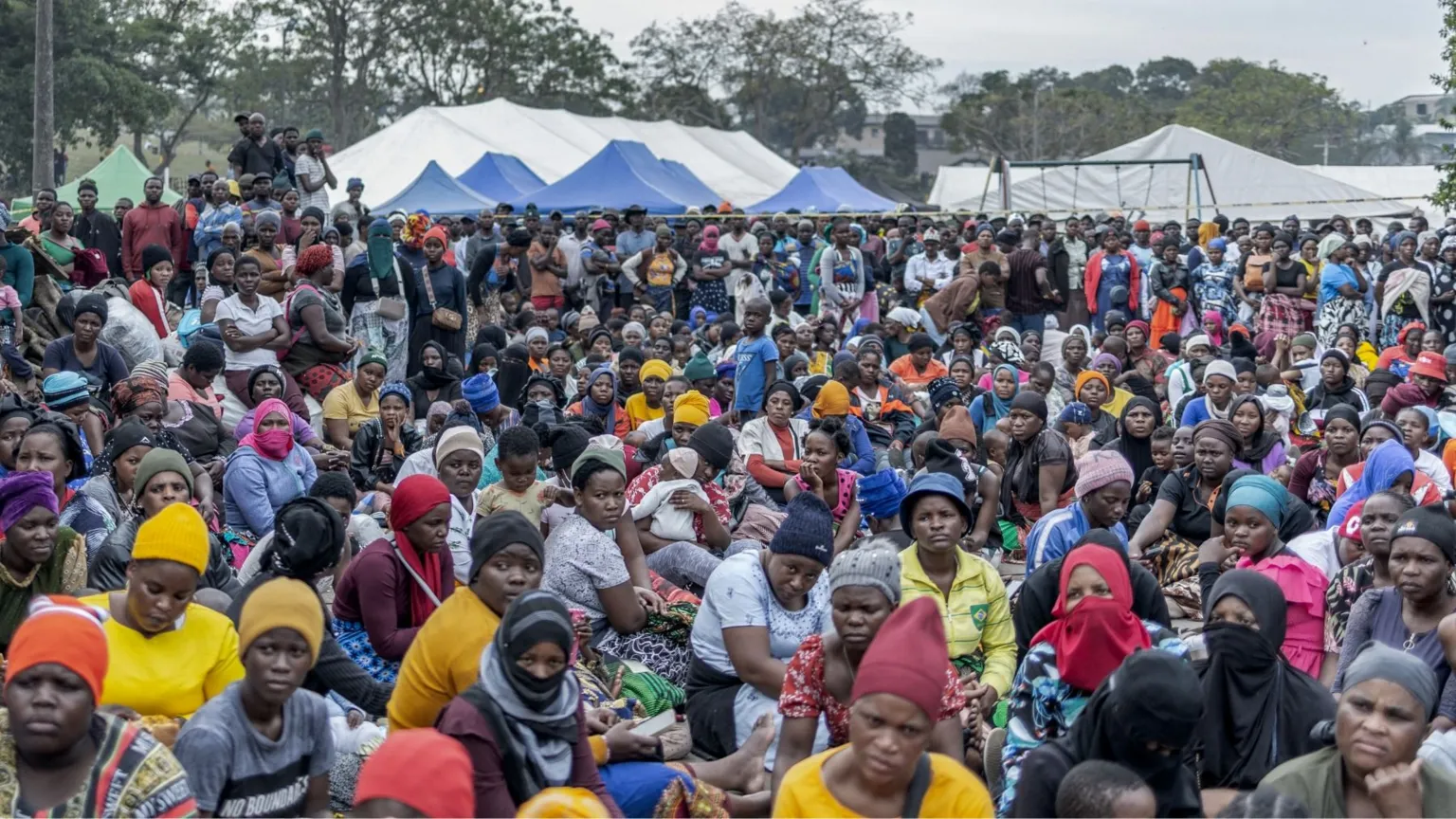 AFP via A big crowd of migrants sitting in an open space in Durban