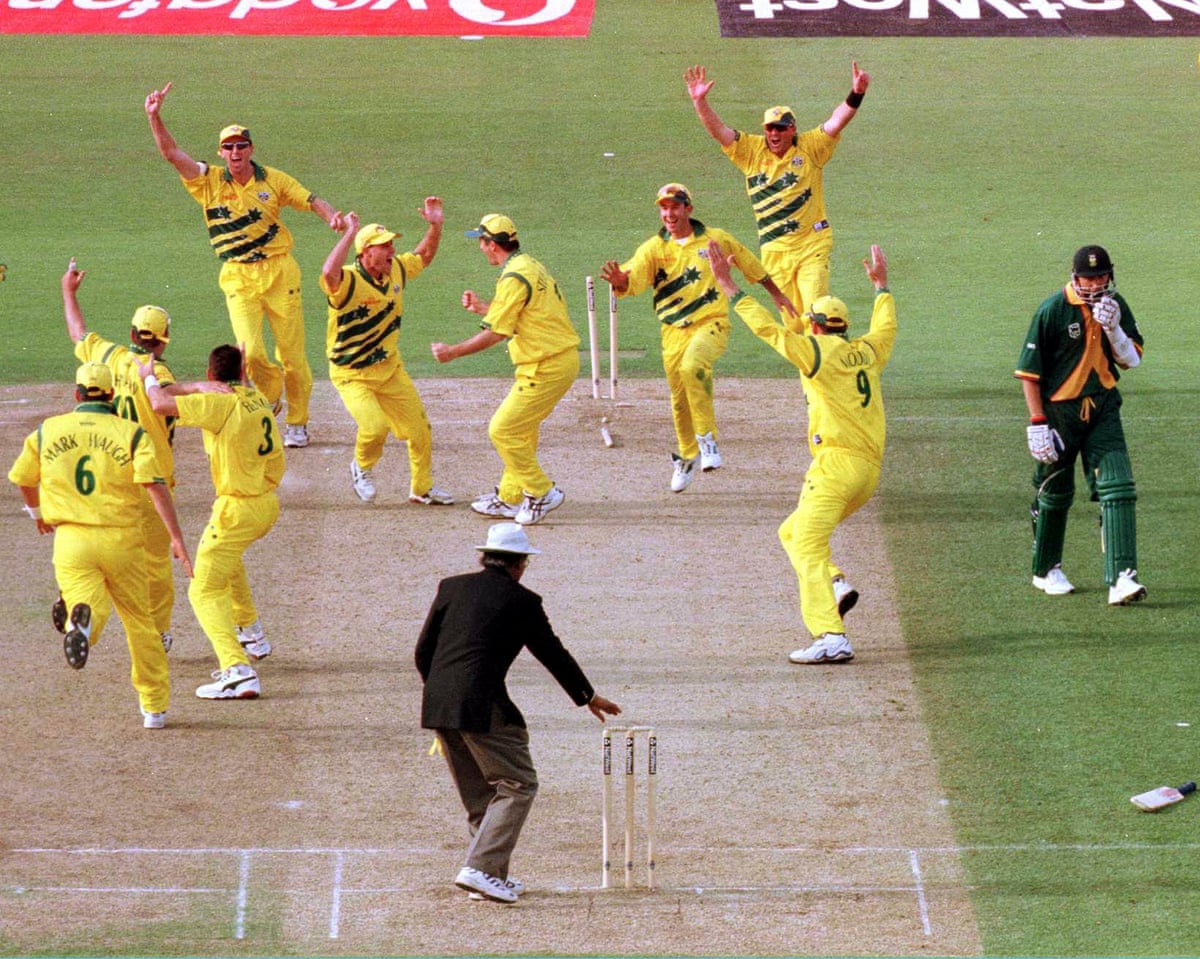 Allan Donald, batting for South Africa, stands dejected in the middle of the pitch while the entire Australia team celebrate a win that put them into the 1999 World Cup final