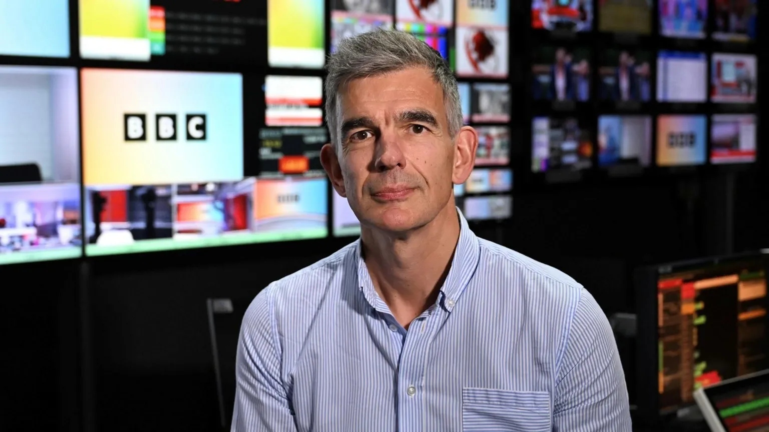 Jeff Overs/BBC Matt Brittin in front of screens in BBC Gallery in June 2026