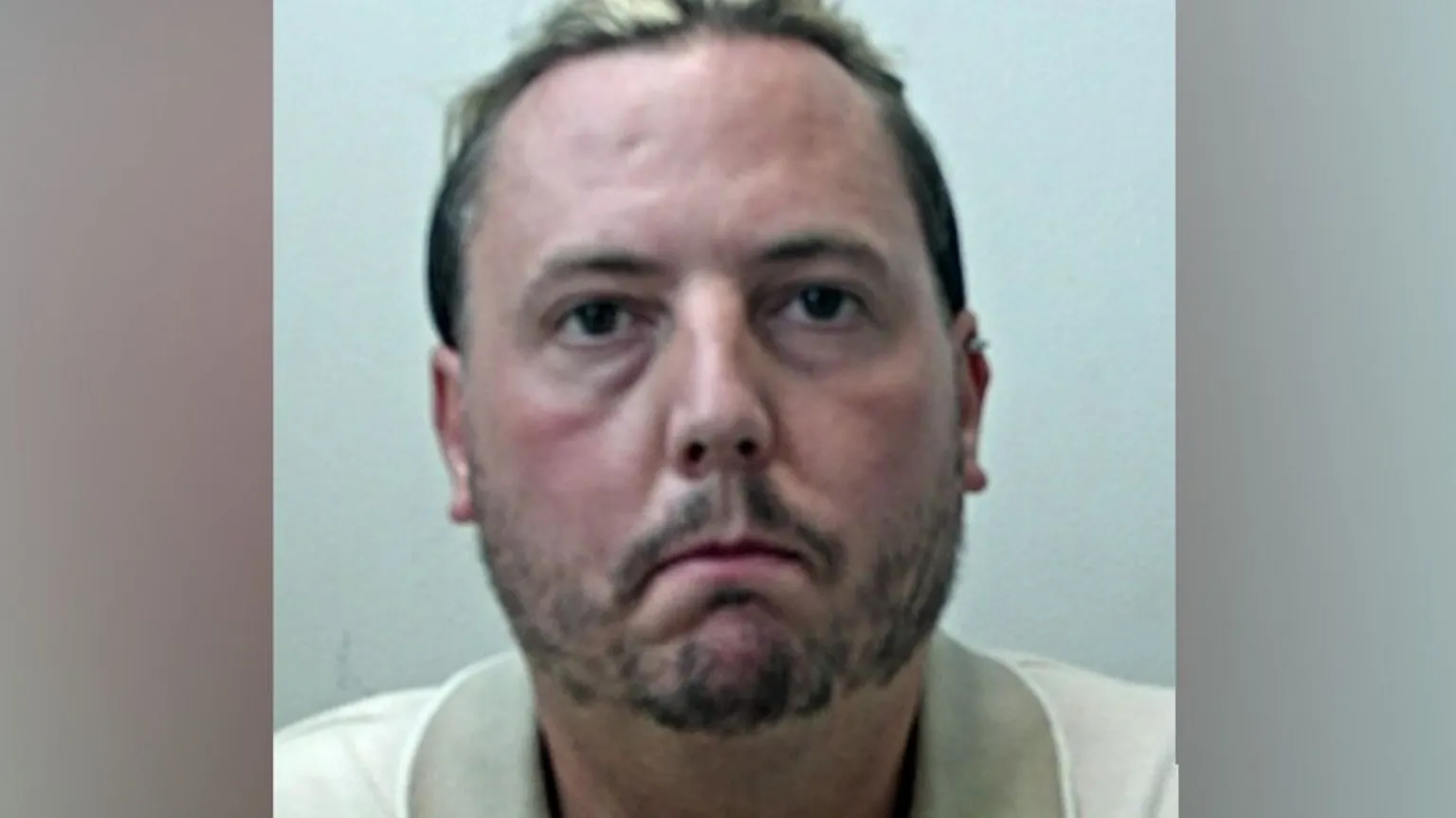 Lancashire Police A mugshot of Jamie Varley, who is wearing a cream polo shirt and staring directly at the camera with no expression on his face.