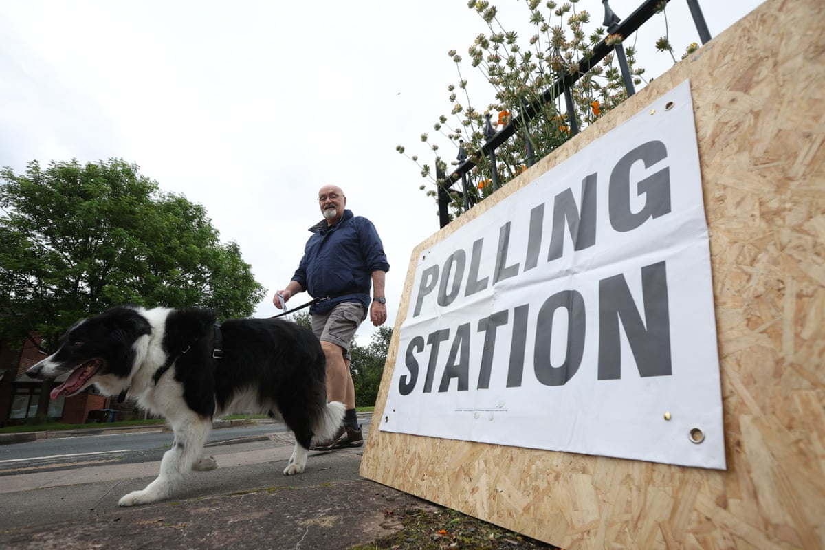 A person at the St Aidan’s Parish Centre polling station with their dog in Wigan, Britain, 18 June 2026.
