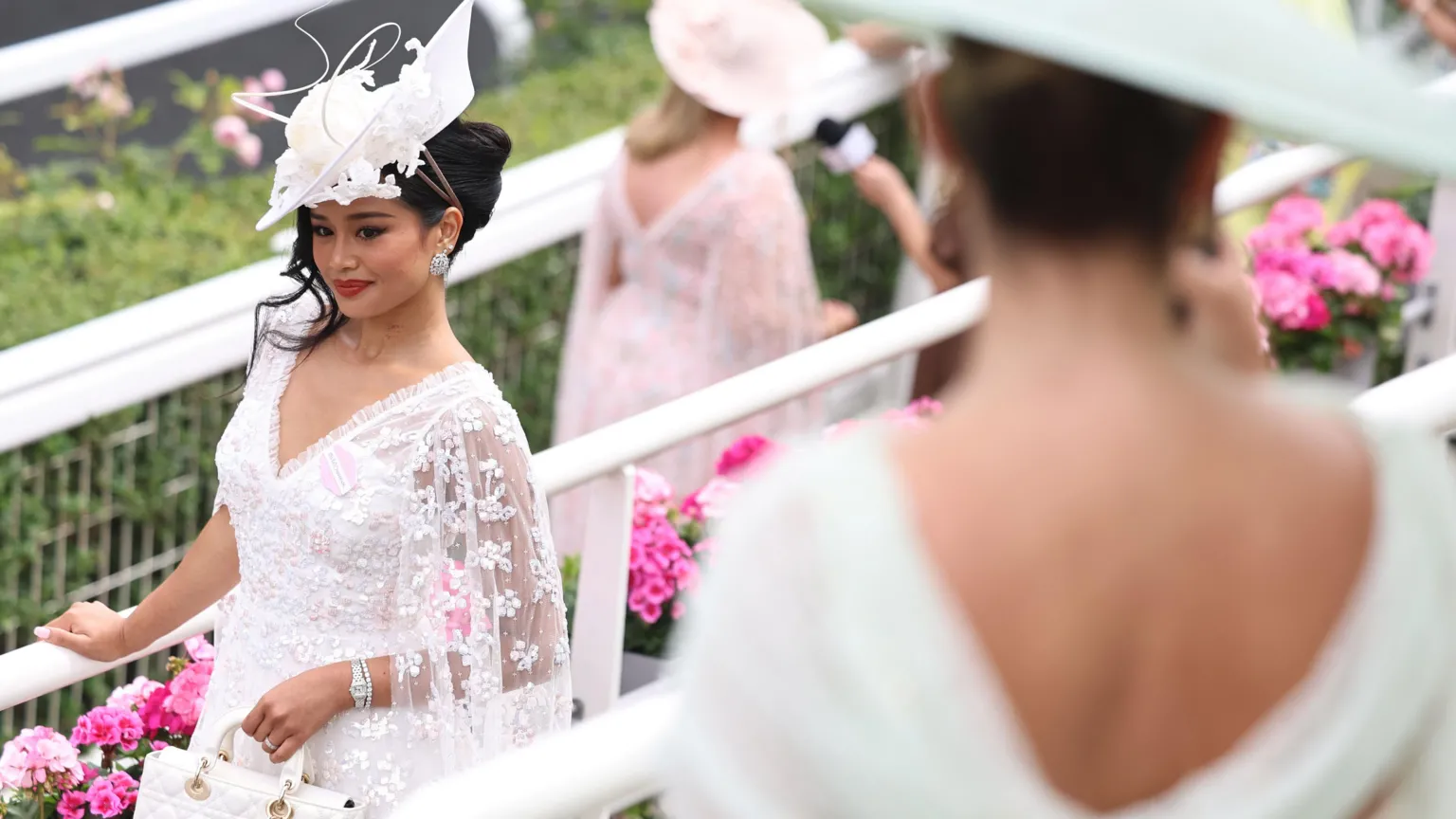 EPA/Shutterstock A woman wearing a white lacy dress and wearing a white fascinator.