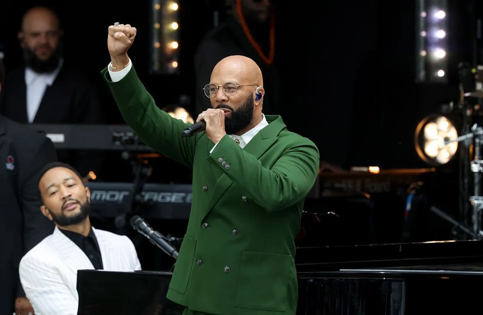 Award-winning rapper Common performs onstage while John Legend plays piano at the Obama Presidential Center in Chicago.