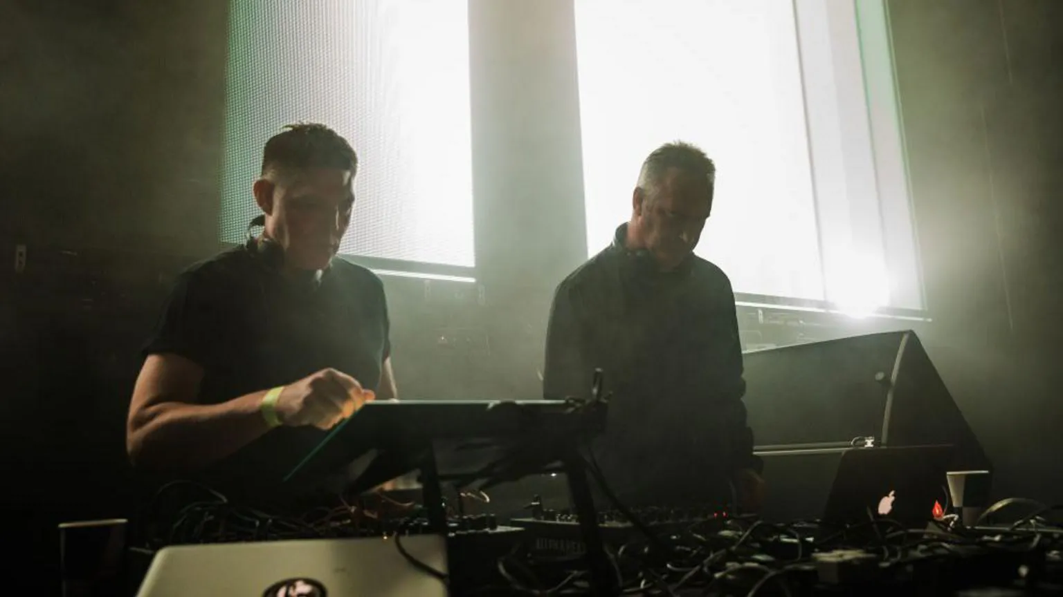  DJ duo Slam performing on stage, standing behind their decks