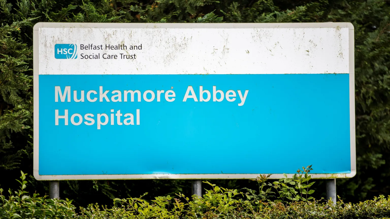 A blue sign that says Muckamore Abbey Hospital