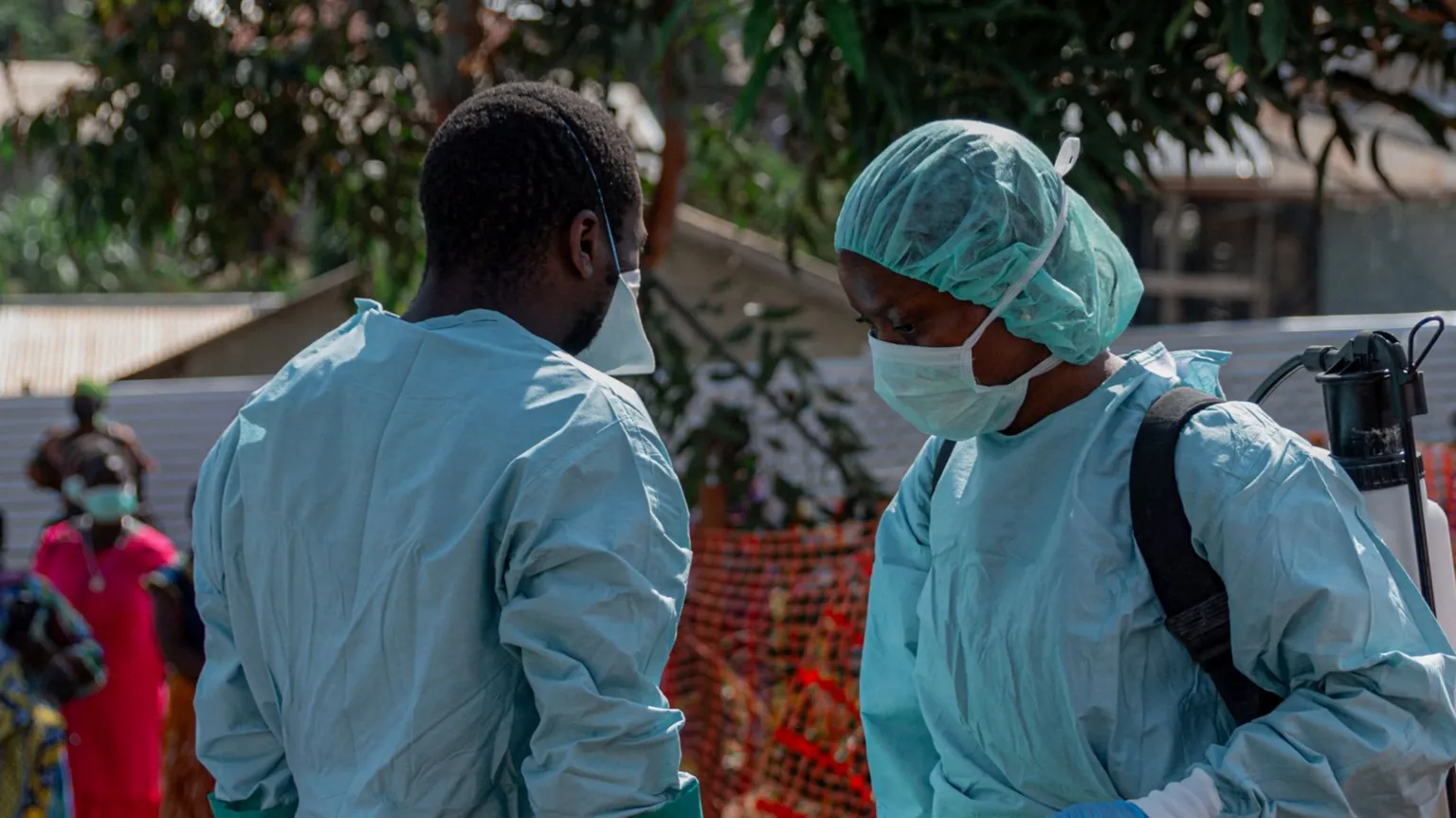 Anadolu via Two health workers are pictured wearing blue protective gear