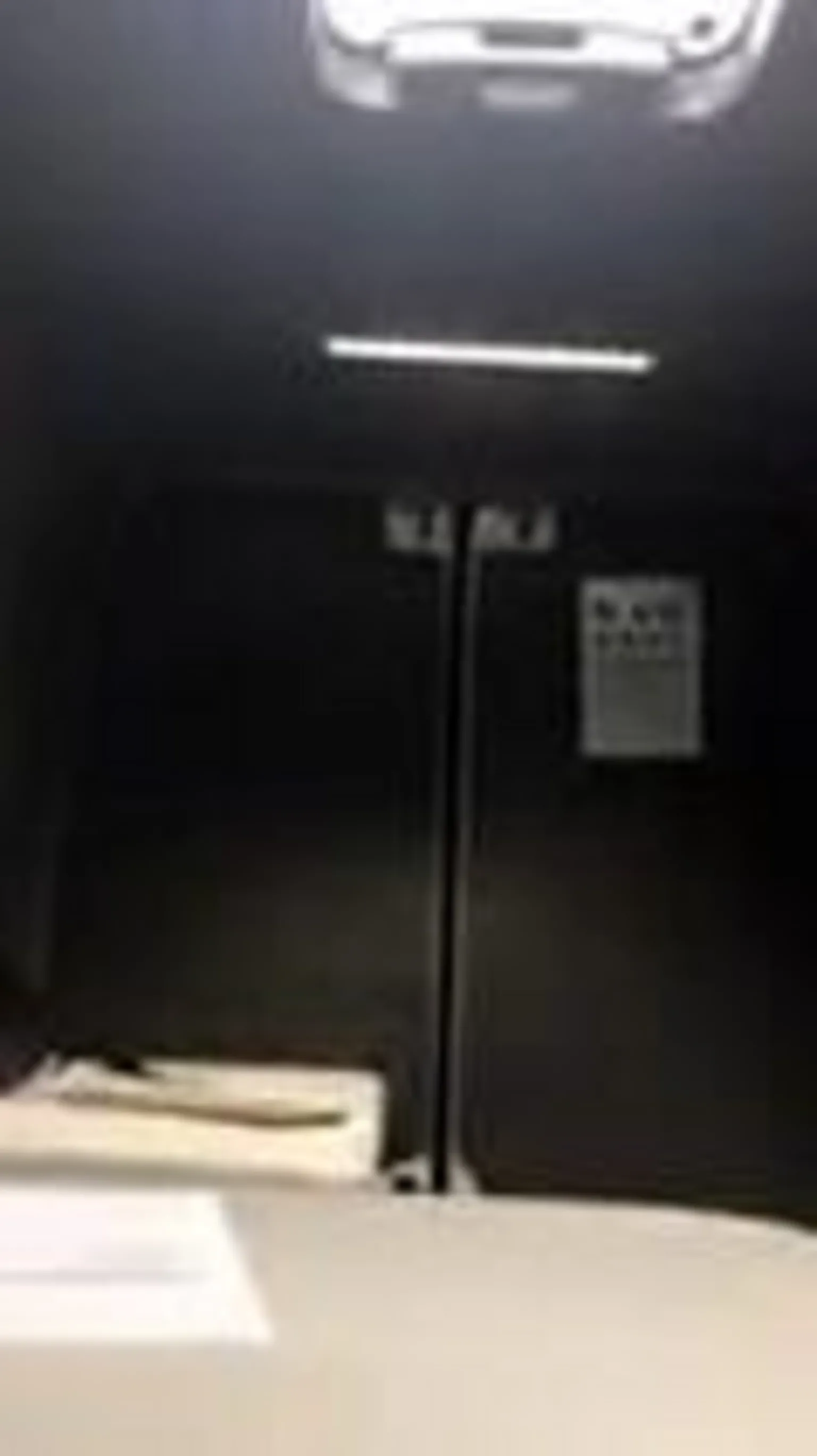 Swansea Trading Standards A grainy image of the interior of a van with a skylight in the roof. Short dark grey carpet covers the internal walls and doors and a small white poster, featuring letters for an eye test hangs on the back wall. 