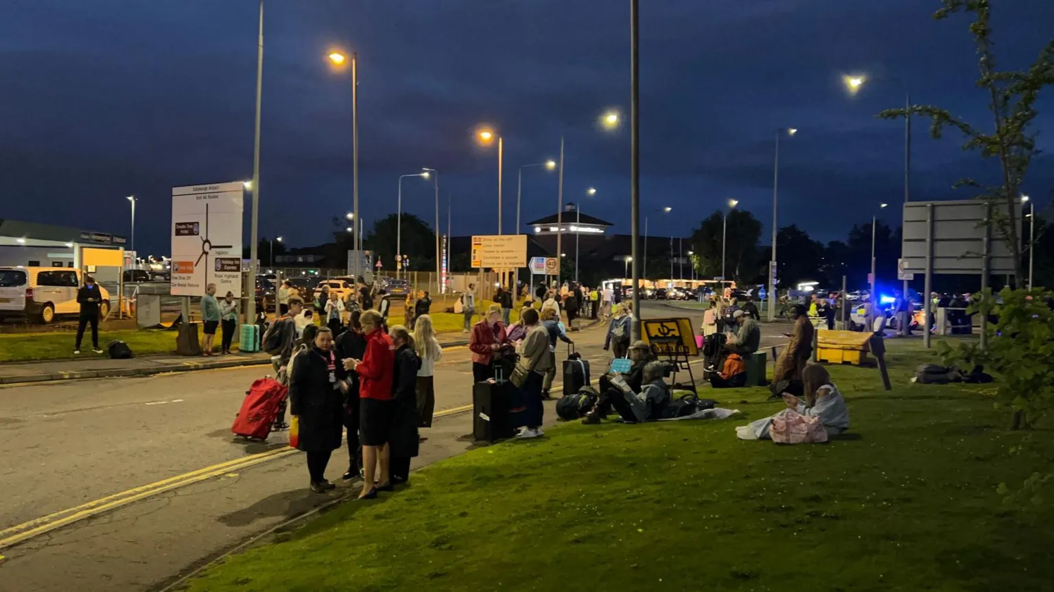 Stranded travellers waiting outside the airport