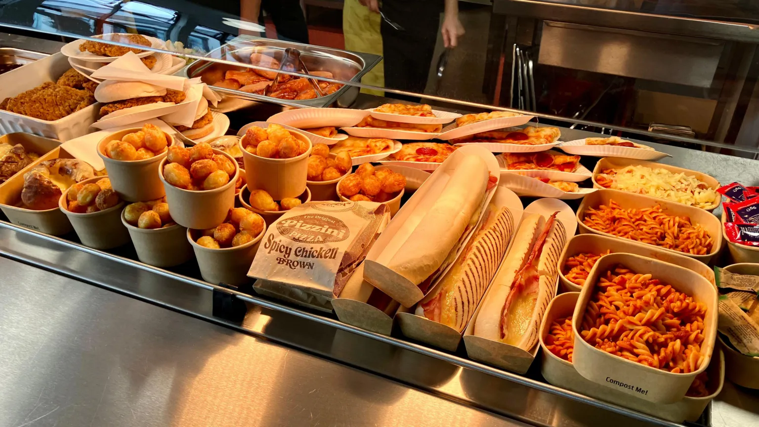 The image shows sandwhiches, burgers, pasta and pizza in the school canteen.