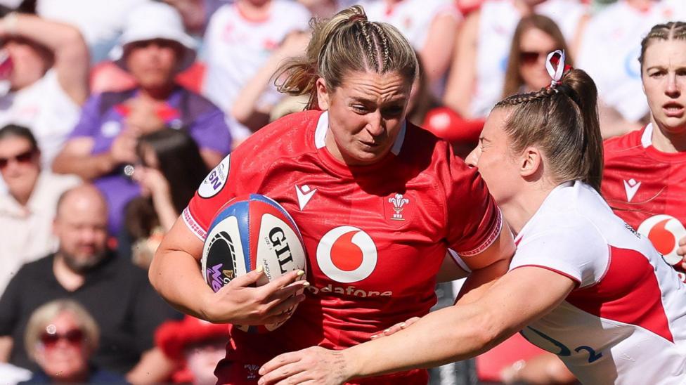 Freya Bell carries the ball for Wales against England