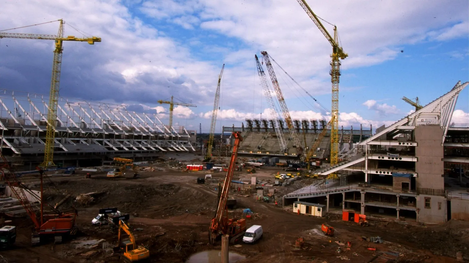 David Rogers/Allsport A view of the Millennium Stadium being built - there are three, half-finished stands around a large patch of mud that will become the pitch. Five different cranes are dotted around and there are various construction vehicles visible as well