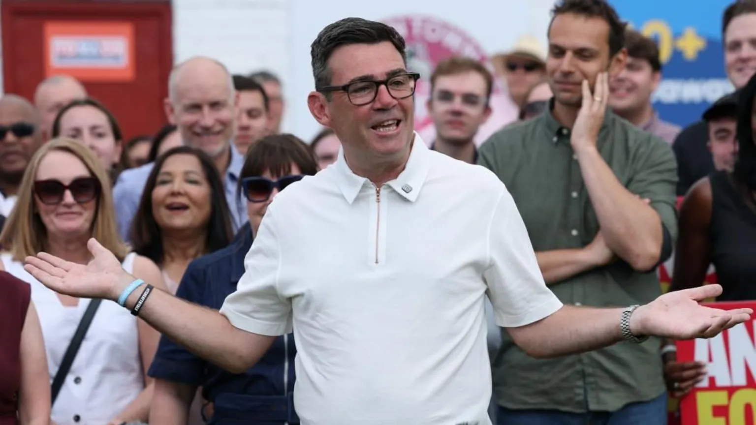 EPA Andy Burnham opens his arms while speaking with a crowd behind him