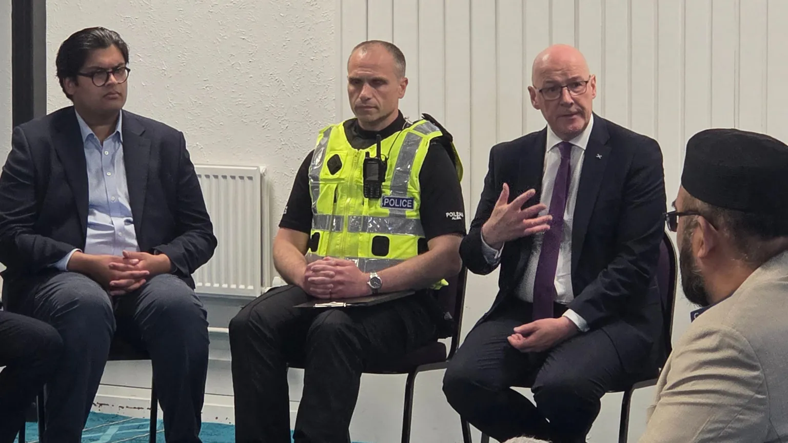 John Swinney, right, wearing a dark suit, speaking to members of the Muslim community at Broomhouse Mosque on Monday.