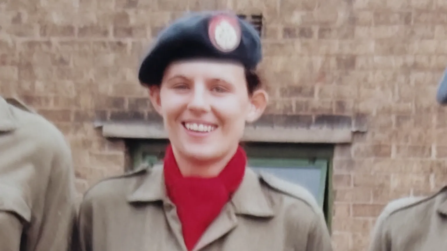Karen Usher A slightly blurry picture taken in the 90s, shows a young girl in an RAF beret, and a red scarf. She is wearing what looks like khaki overalls.