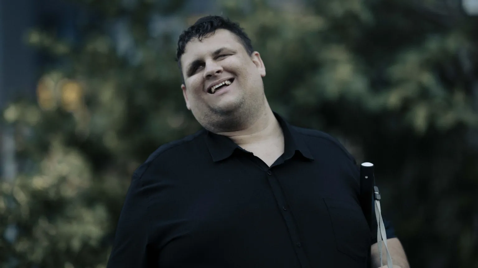 Rebecca Parker A man wearing a black shirt, carrying a white cane
