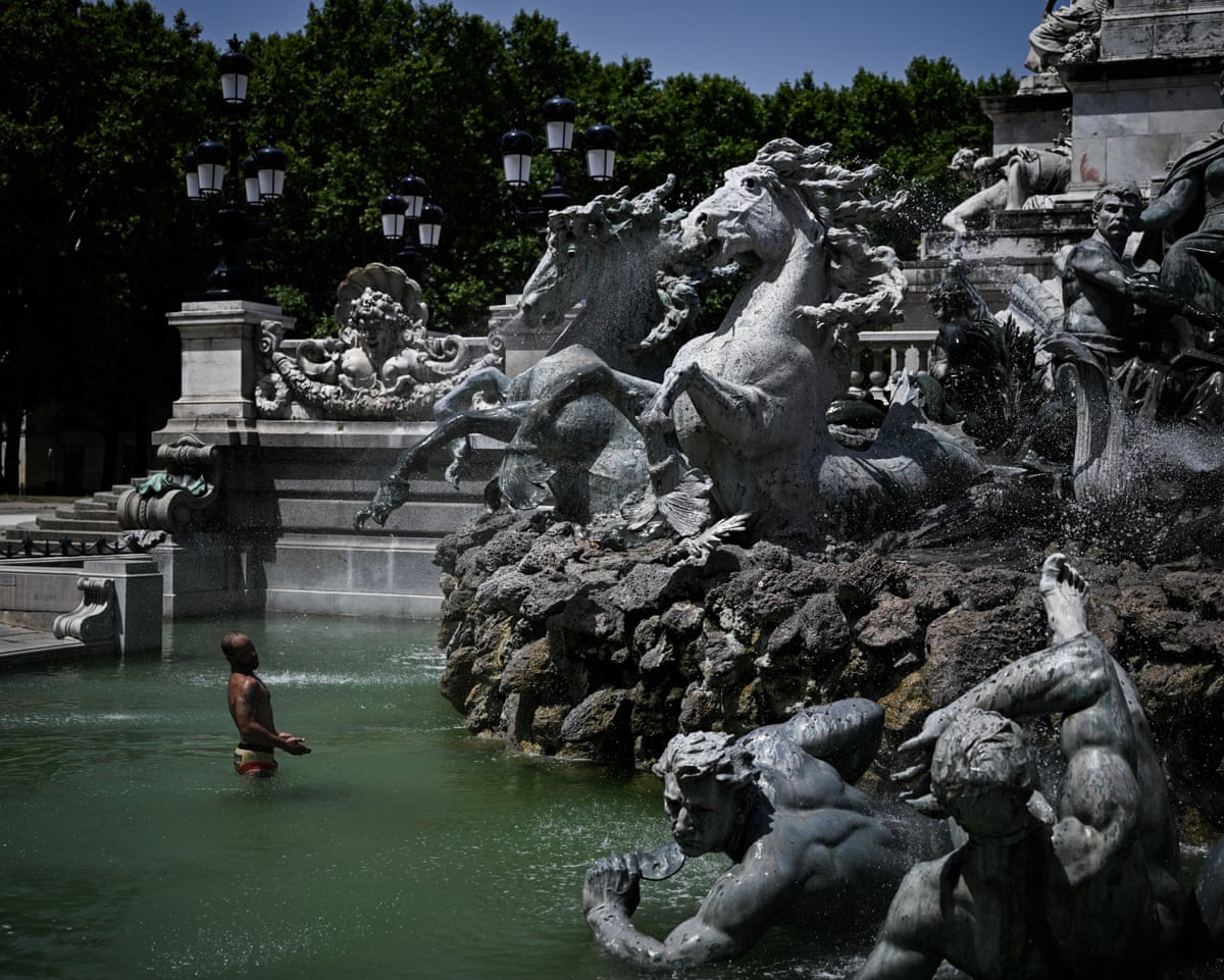 A man cools off in the basin of the Girondins Fountain at Place des Quinconces in Bordeaux, south-western France