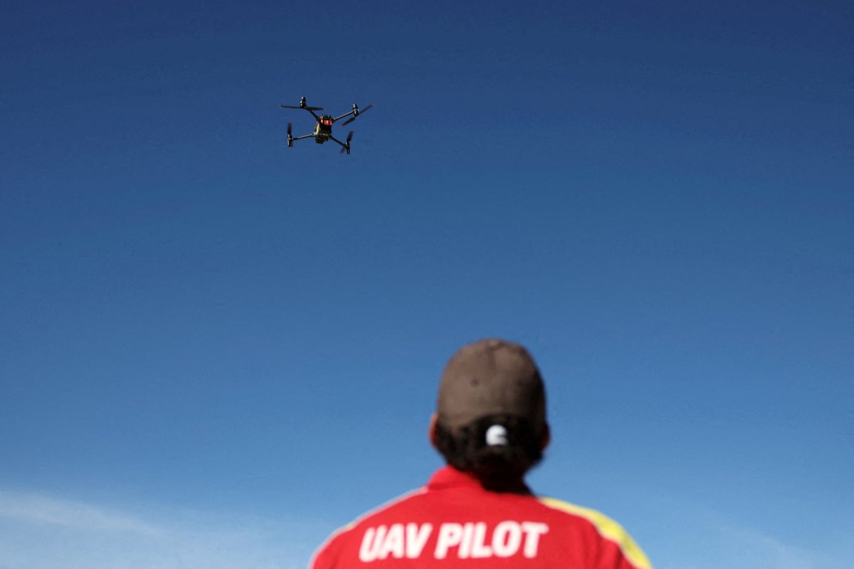 An unmanned aerial vehicle pilot flies a surf life saving shark-spotting drone at Coogee beach in Sydney.