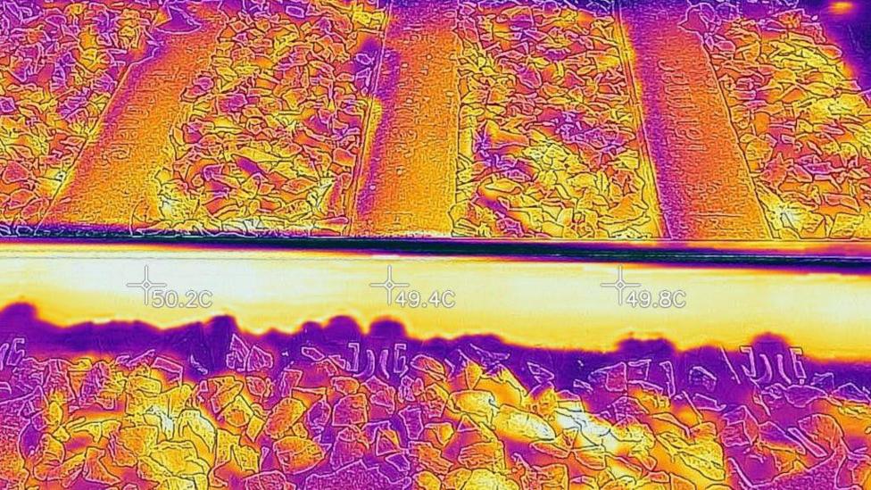 Thermal image of railway tracks showing heat distribution across rails and ballast for monitoring track condition, with temperature readings 49–50C.