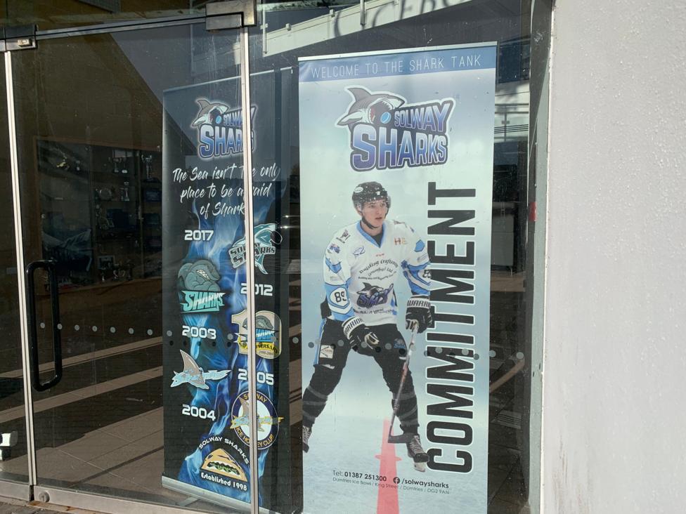 A poster advertising the Solway Sharks games with an ice hockey player and the word