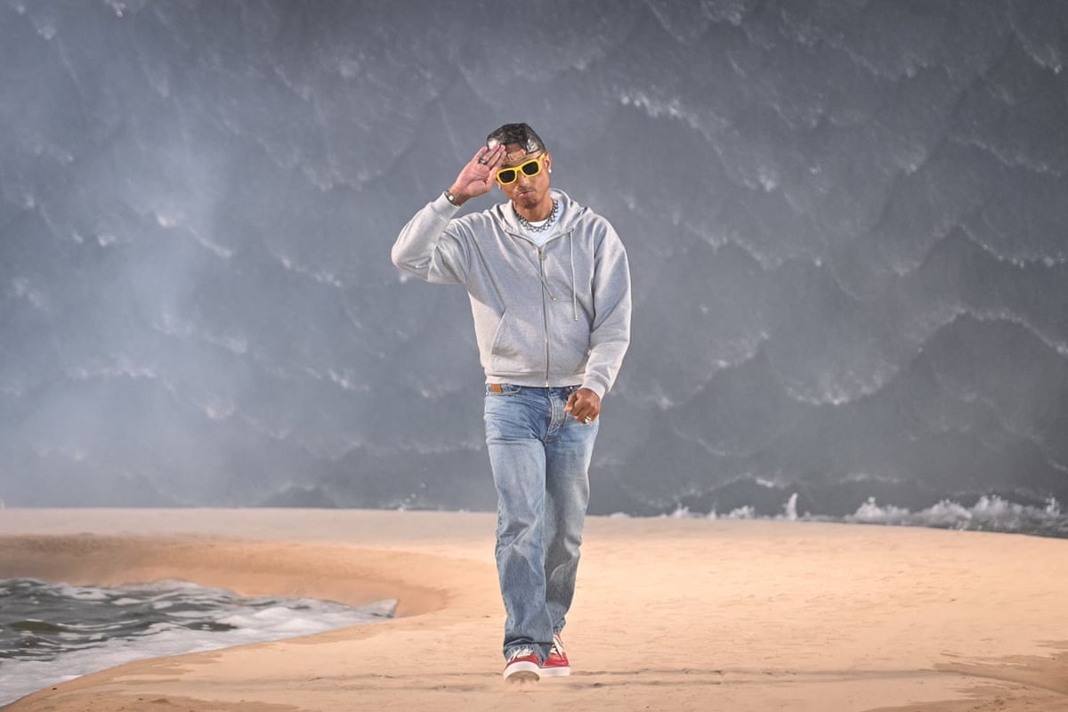 The designer Pharrell Williams salutes the crowds at the end of his Louis Vuitton show.