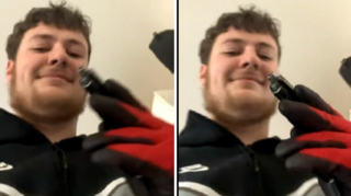Huntley has dark brown hair, a beard and is smiling at the camera. He's holding the pistol up the camera and wearing black and red gloves